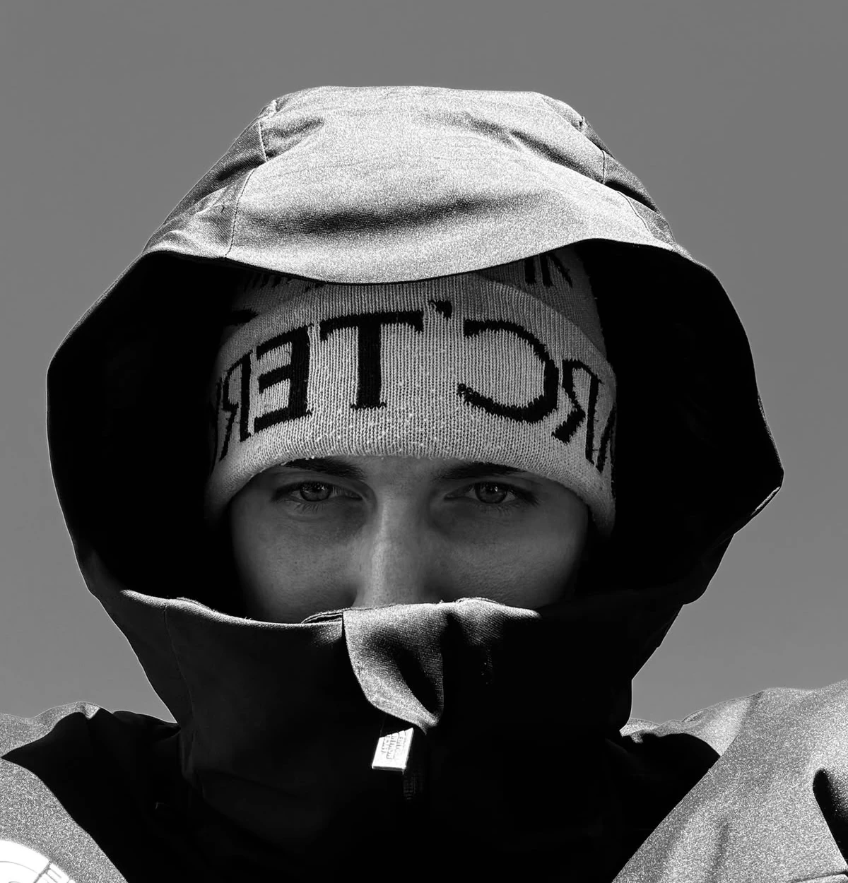 Black and white portrait of Toby in a beanie and winter jacket